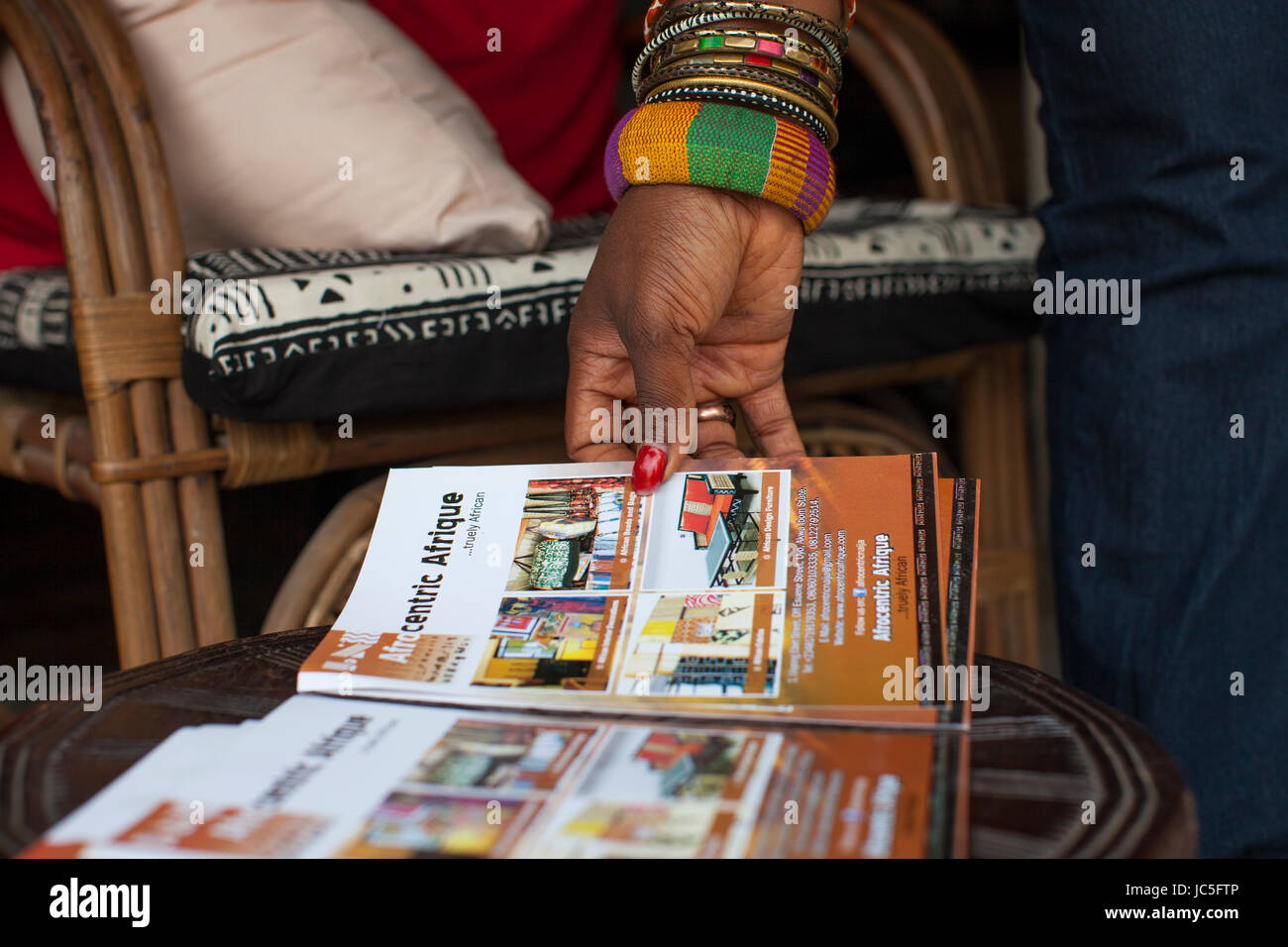 Una donna navigazione attraverso una brochure, Nigeria, Africa. Foto Stock