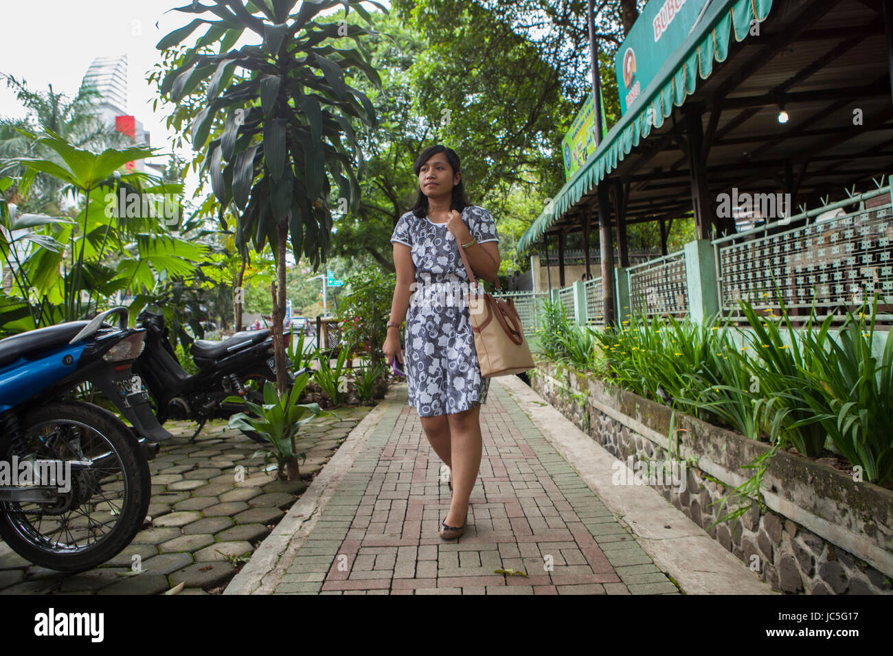 Una donna che cammina lungo la strada, Indonesia, Asia. Foto Stock