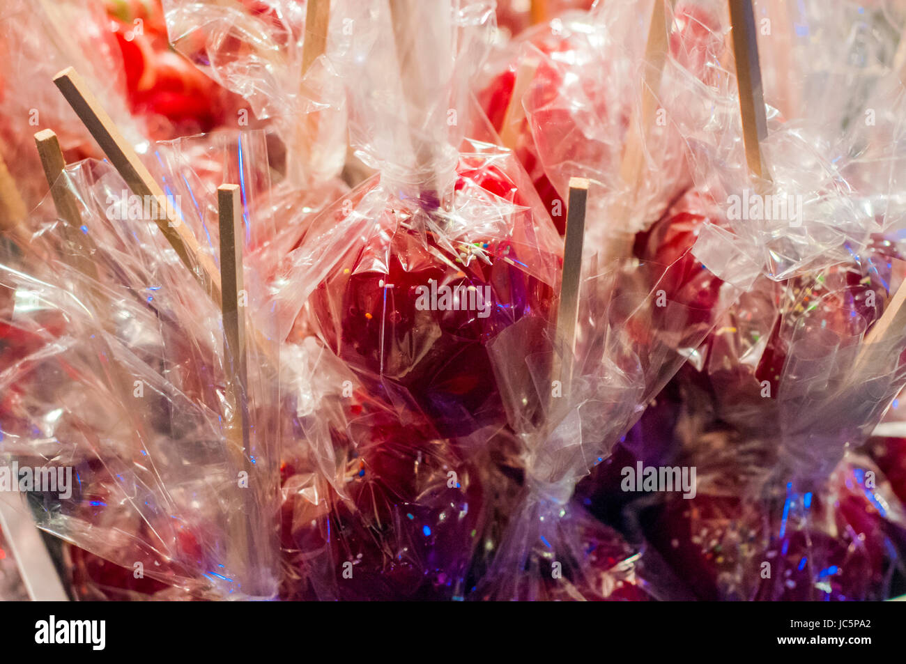 Dolce rosso smaltato toffee candy mele su bastoni per la vendita sul mercato contadino o country fair. Delizioso rosso caramella mele ricoperta di granelli colorati. Foto Stock