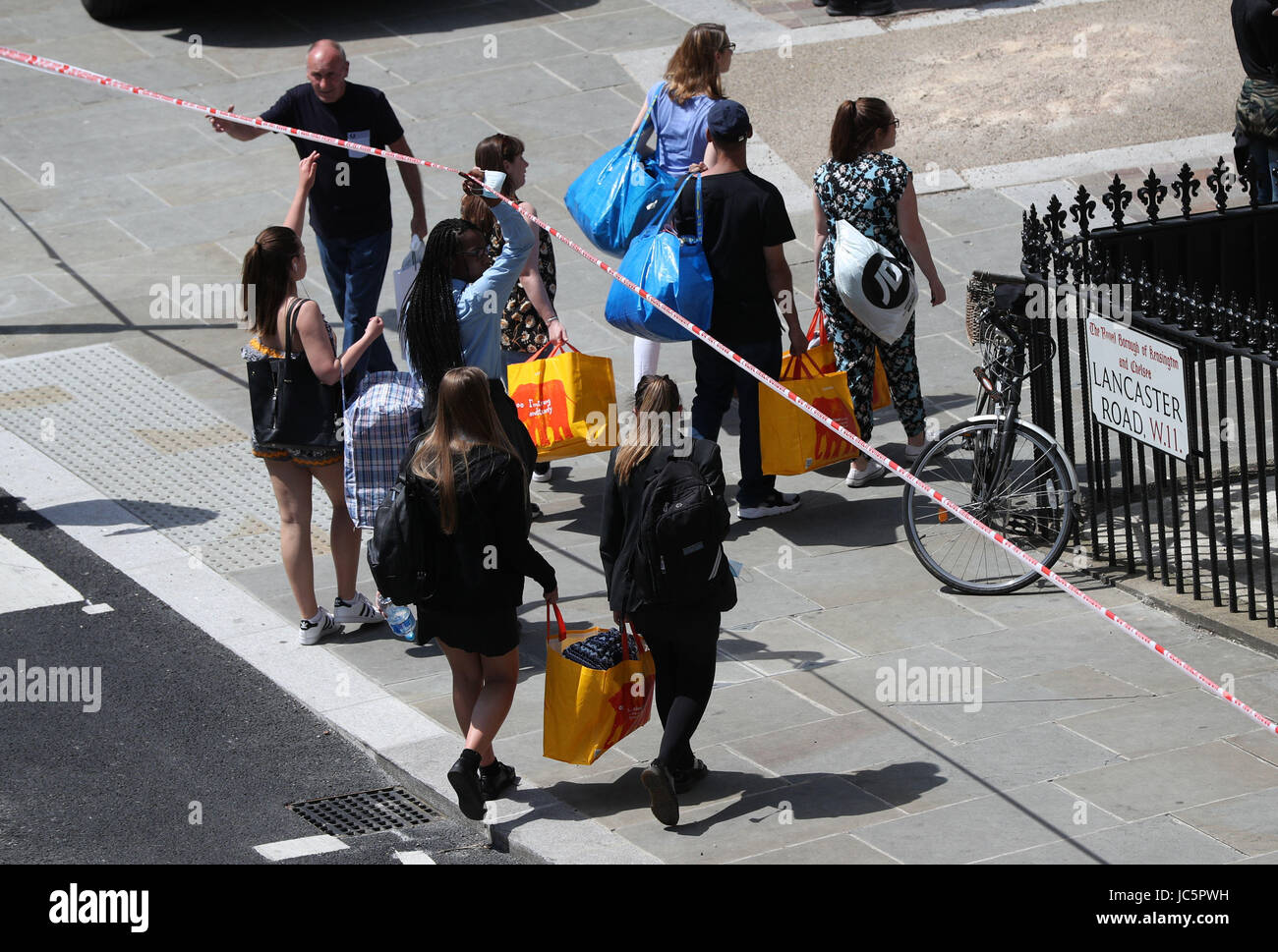 I membri del pubblico di portare cibo e acqua per aiutare le persone colpite da un incendio che ha inghiottito la 24 piani Grenfell Torre nel West London. Foto Stock