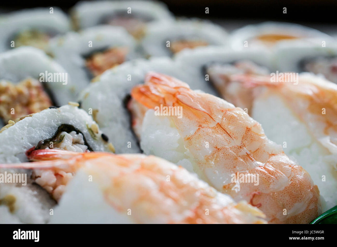 Disposte orizzontalmente il sushi di gamberi e rotoli venduti nella casella Foto Stock