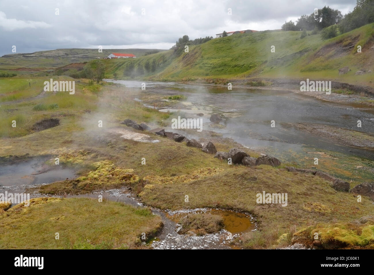 Vista della laguna segreta. Islanda più antichi della piscina, Islanda, mostrando il vapore da hot springs Foto Stock