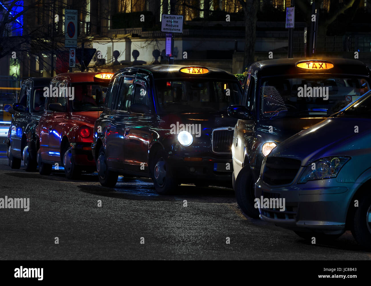 Londra taxi neri con noleggio giallo luci accese in Londra Foto Stock