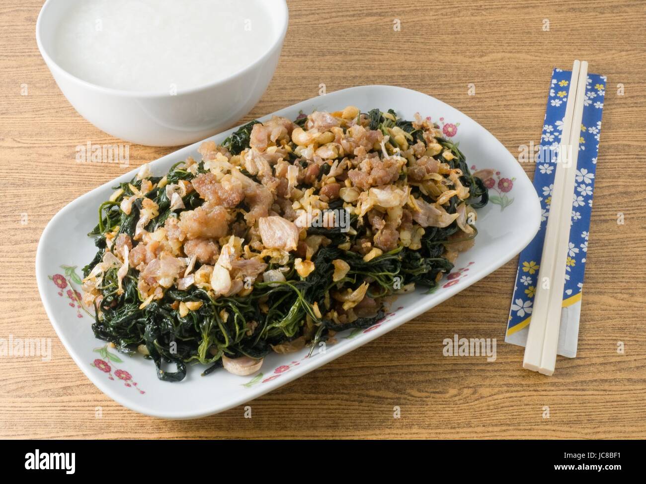 Cinese tradizionale cibo, saltate in padella Foglie di iuta o Mulukhiyah foglie con carne macinata di maiale, Garlics e fermentati di soia servito con Soft riso bollito. Foto Stock