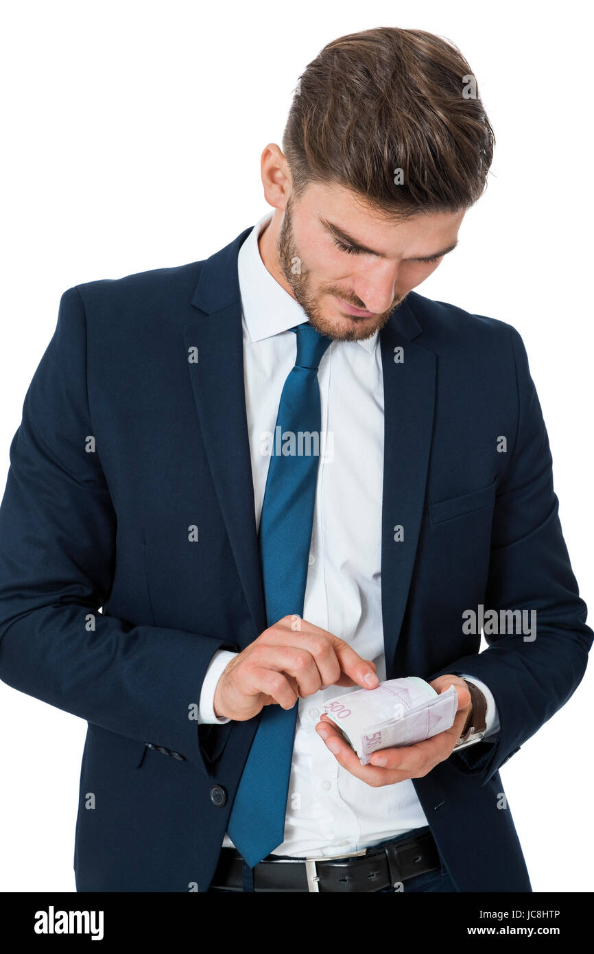 Wohlhabender erfolgreicher Geschäftsmann jungen mit einer Handvoll von Euro-Banknoten Mit einem glücklichen Lächeln zeigt seinen isoliert Wohlstand auf weiß Foto Stock