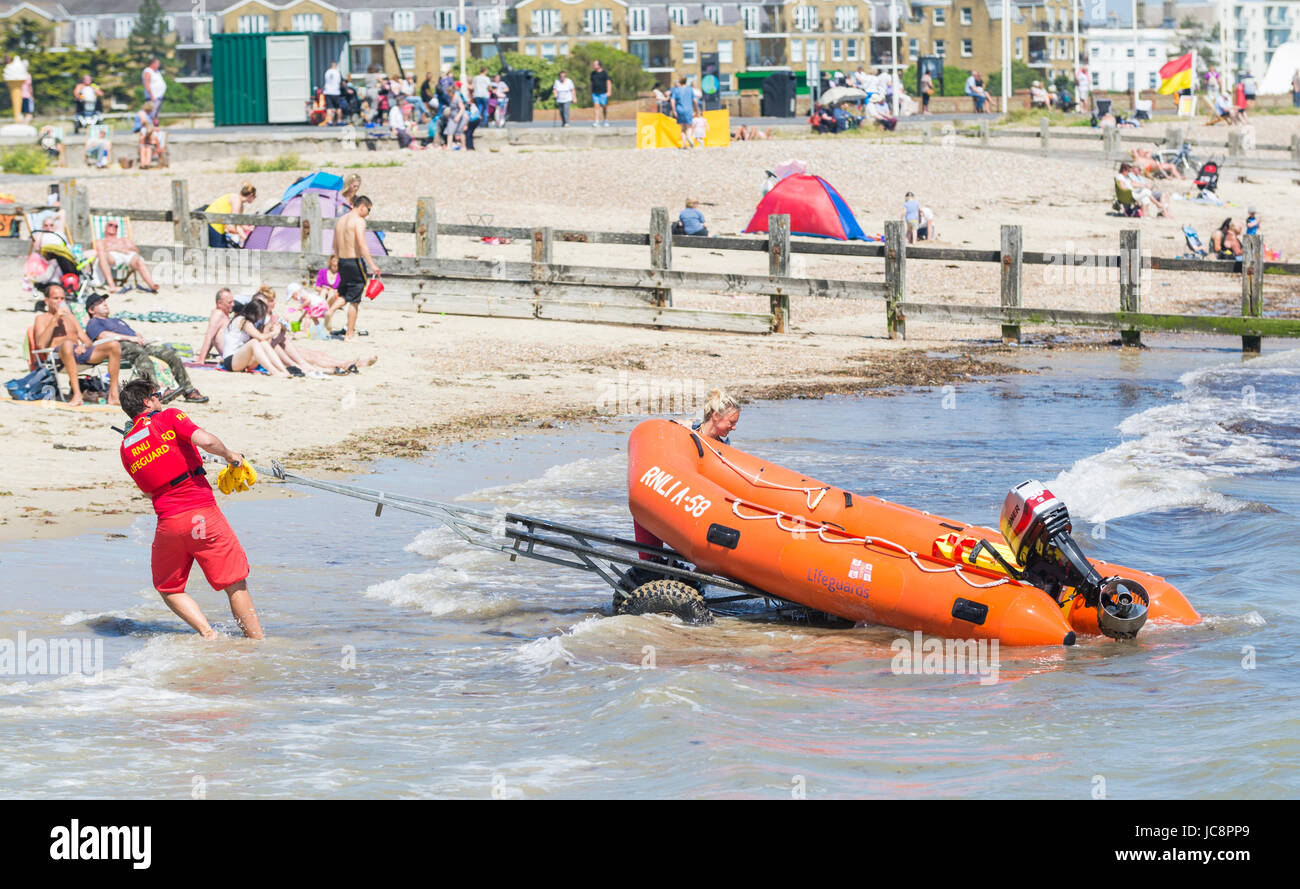 RNLI bagnini di preparare una nervatura di corsa fuori per un incidente in una calda giornata estiva nel giugno 2017 in Littlehampton, West Sussex, in Inghilterra, Regno Unito. Foto Stock