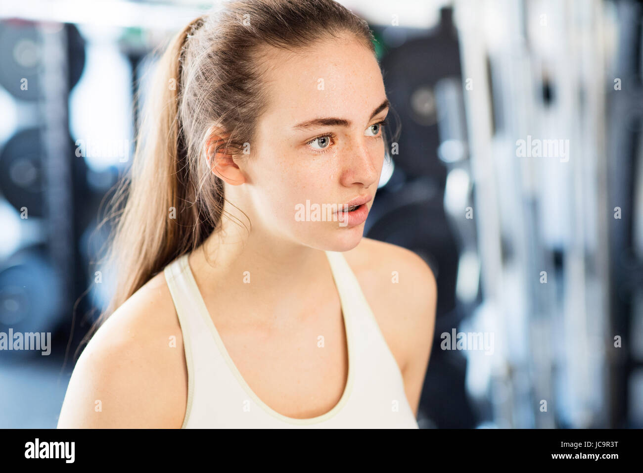 Giovane donna in palestra, in vasca bianca in alto, appoggiato Foto Stock