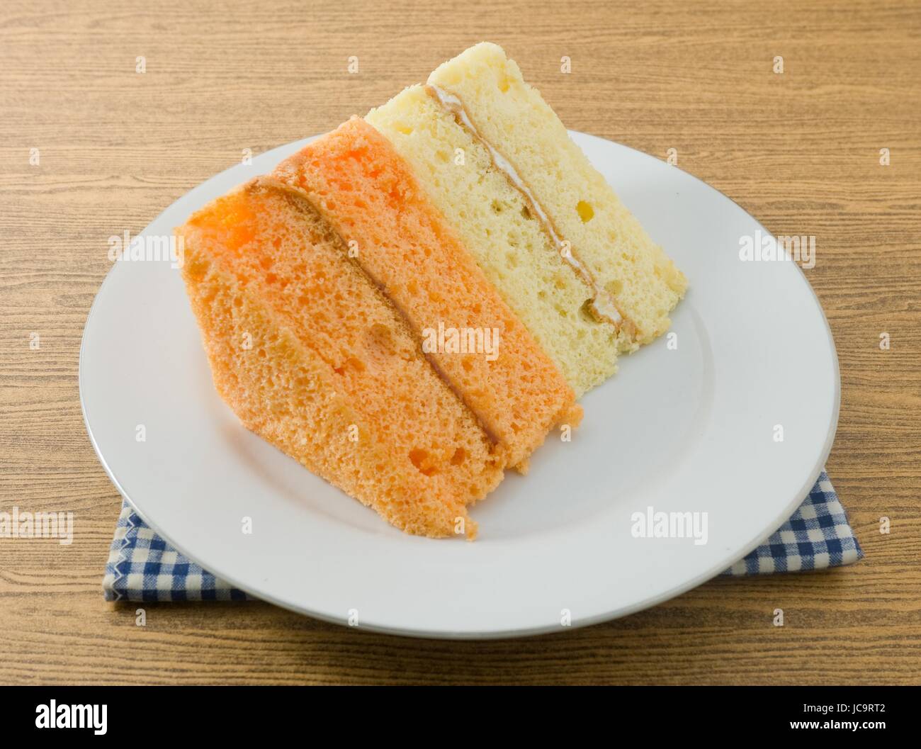 Snack e Dessert, vaniglia e Orage Chiffon torta fatta con burro, uova, zucchero, farina, il lievito in polvere e aromi su un piatto bianco. Foto Stock