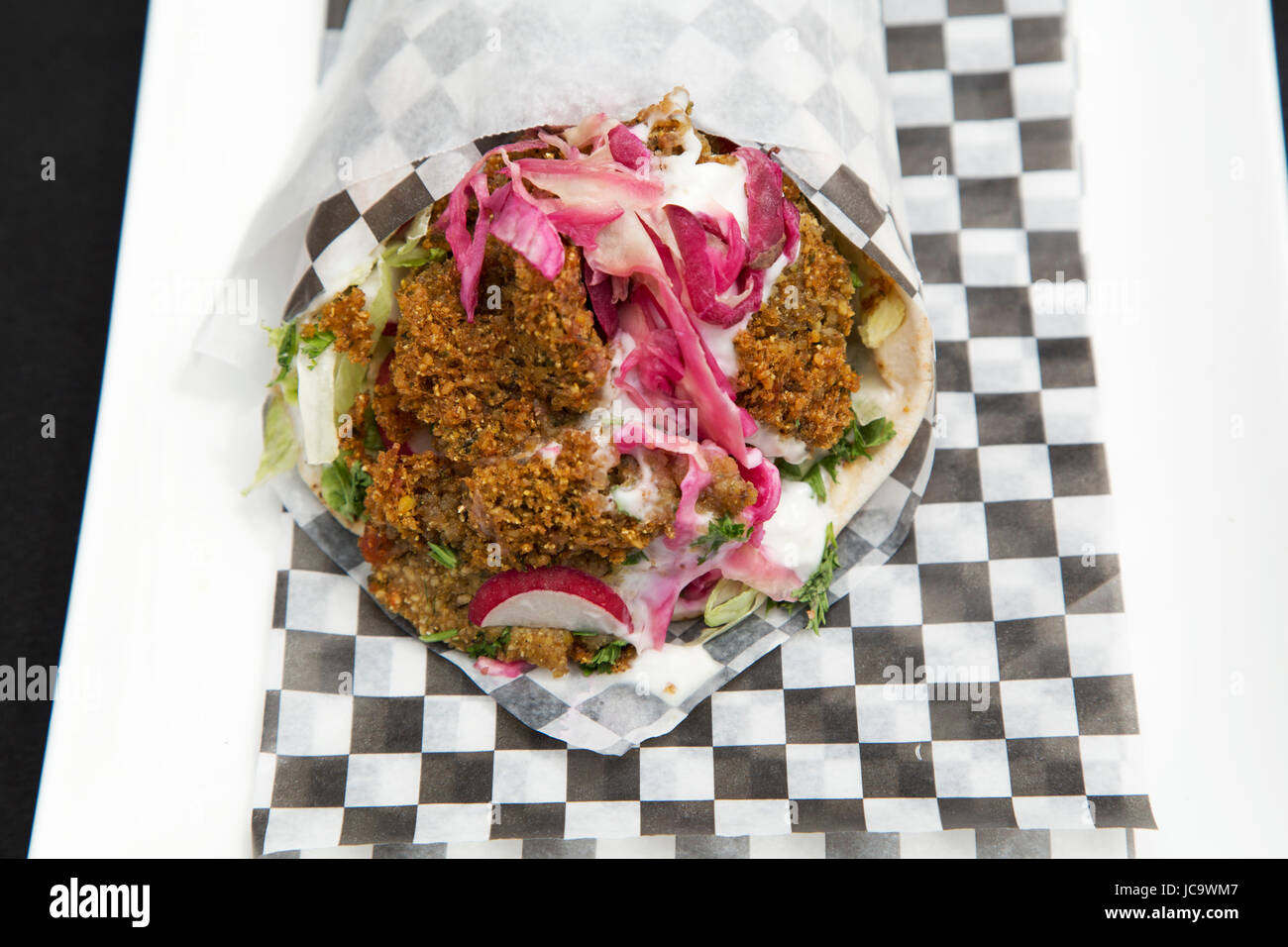Un falafel wrap è servita a Calgary, Canada. Immigrazione e influenze globali significa una vasta varietà di cucine sono serviti nelle principali città. Foto Stock