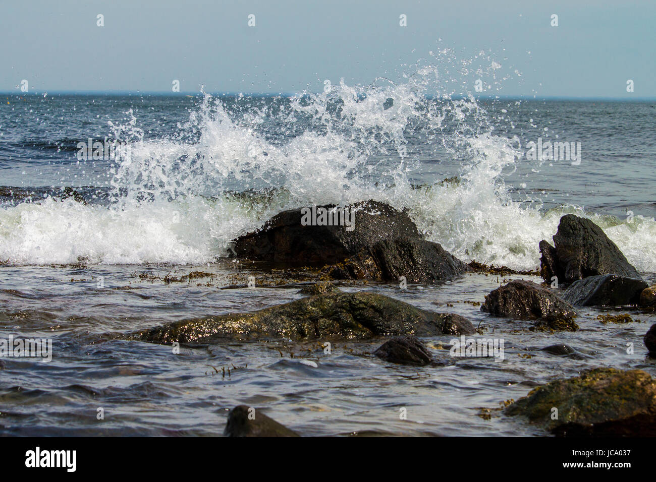 Una foto di una rottura d'onda su una roccia. Foto Stock