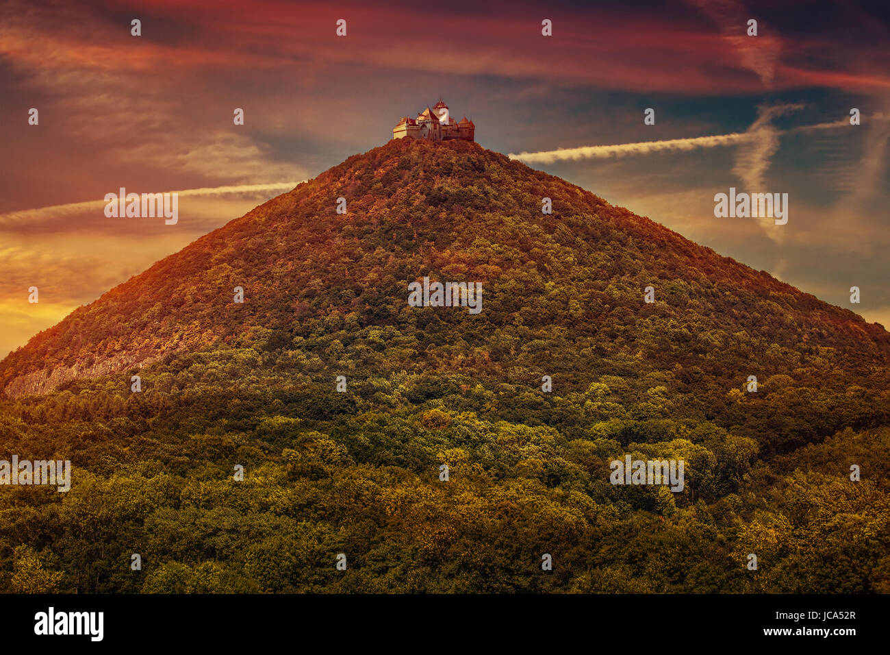 Castello di alta montagna top con la foresta al tramonto colori rosso Foto Stock
