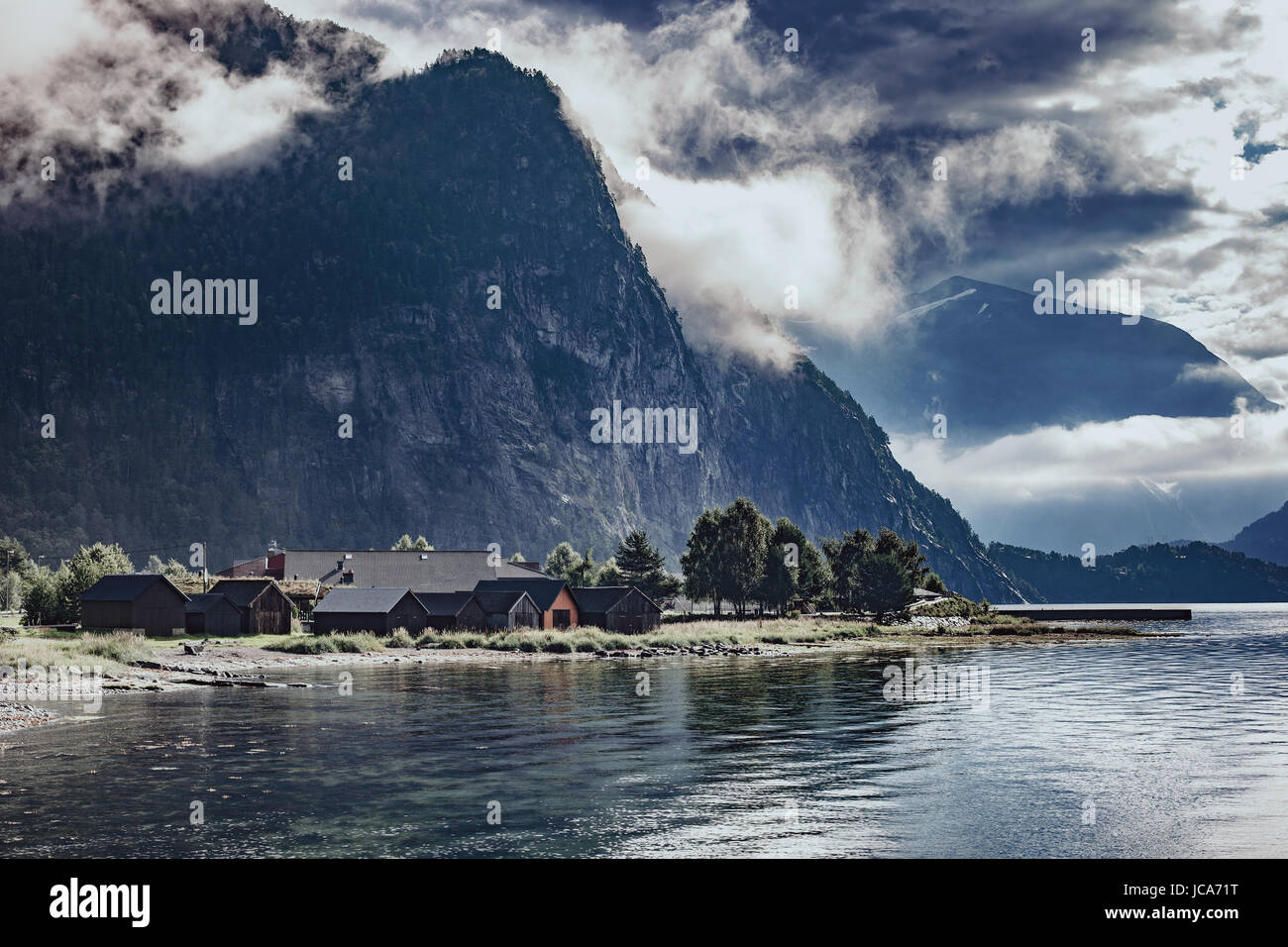 Norvegia fjord drammatico paesaggio con montagne, acqua ed edifici Foto Stock