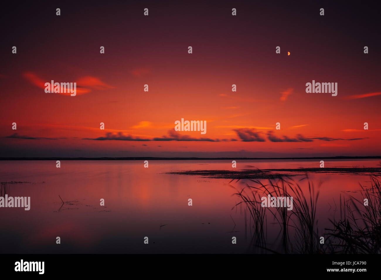 Soft dark caldi colori dello sfondo con il lago e il cielo al tramonto. Lunga esposizione. Foto Stock