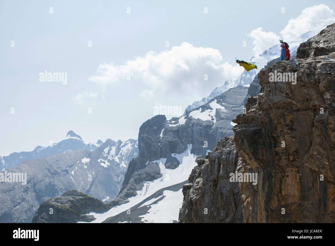 Ponticello di base Neil Amonson uscendo da una scogliera nelle Alpi Svizzere. Foto Stock