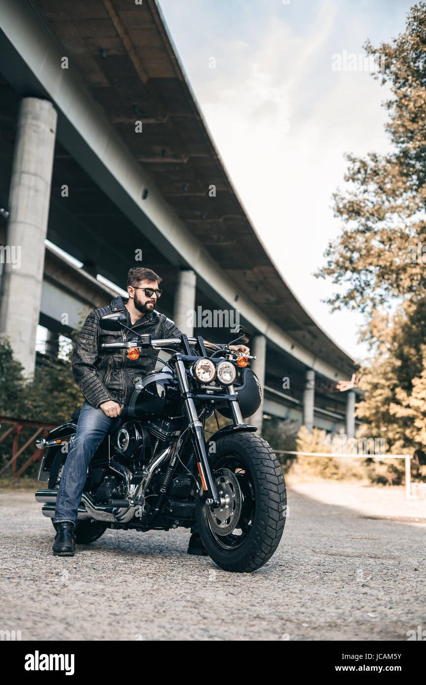 Biker uomo che indossa jeans e giacca di pelle Foto Stock