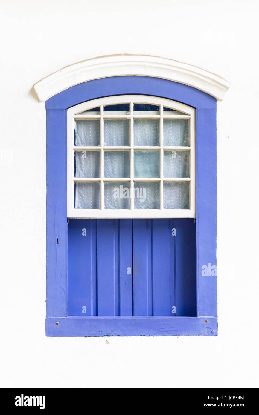 Decorative, coloniale, blu, vintage, finestra su una parete bianca a Paraty (o Parati), Brasile. Foto Stock