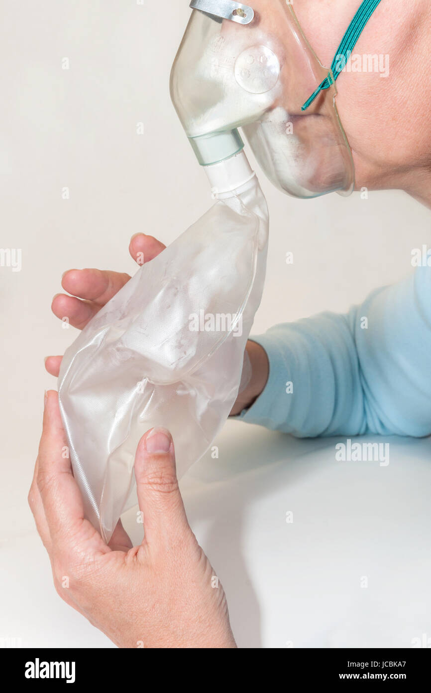 Untere Gesichtshälfte und Hände einer Frau mit Hyperventilationsmaske Foto Stock