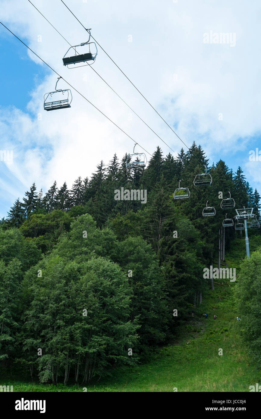 Bassa angolazione di aria alpina ascensore con alberi in background Foto Stock