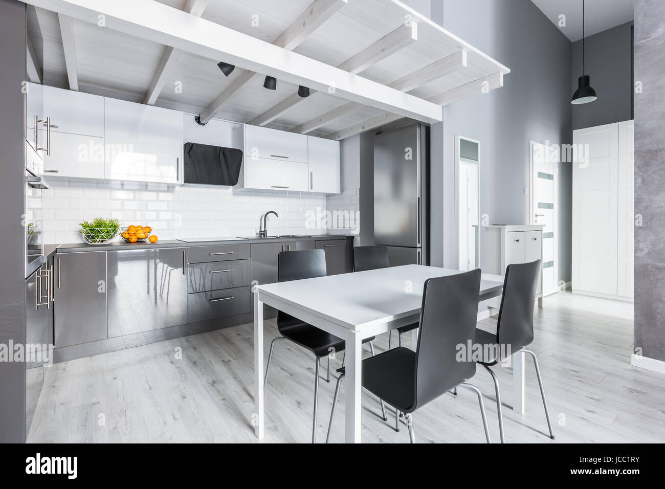 Cucina grigio bianco con tavolo da pranzo e sedie nere Foto stock - Alamy