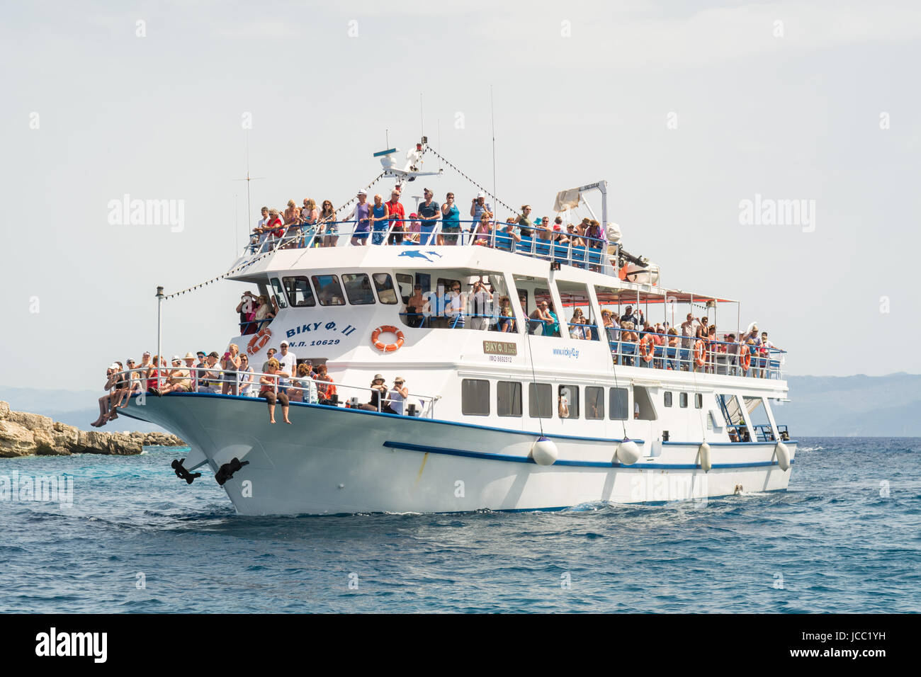 Corfù a Paxos e Antipaxos - Giornata di escursione in barca di viaggio pieno di turisti da Parga sulla terraferma greca arrivando a Loggos, Paxos, Grecia Foto Stock