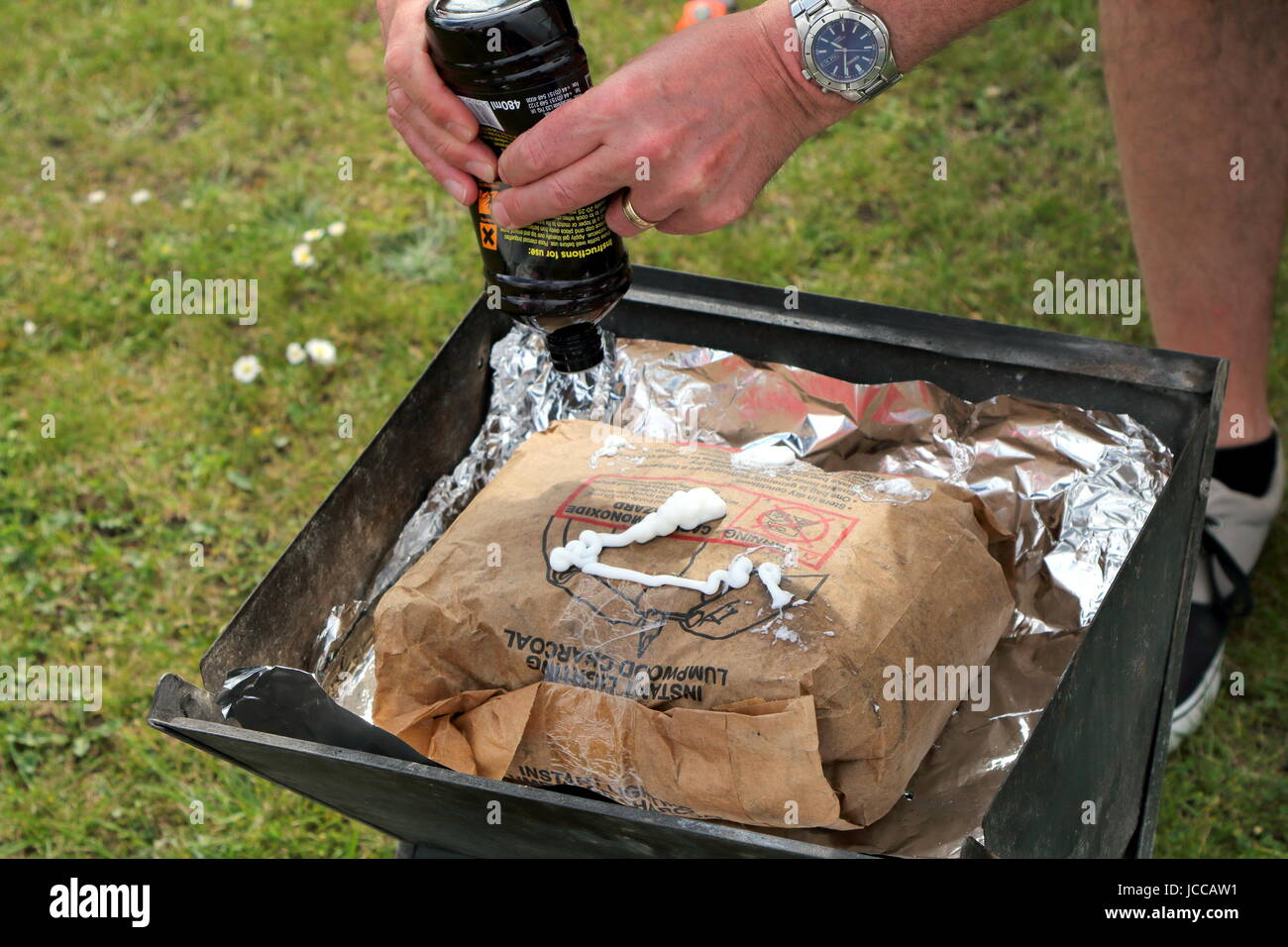 St Leonards, Hampshire, Regno Unito - 30 Maggio 2017: aggiunta di gel di illuminazione di un sacchetto di illuminazione istantanea lumpwood carbone per barbecue Foto Stock