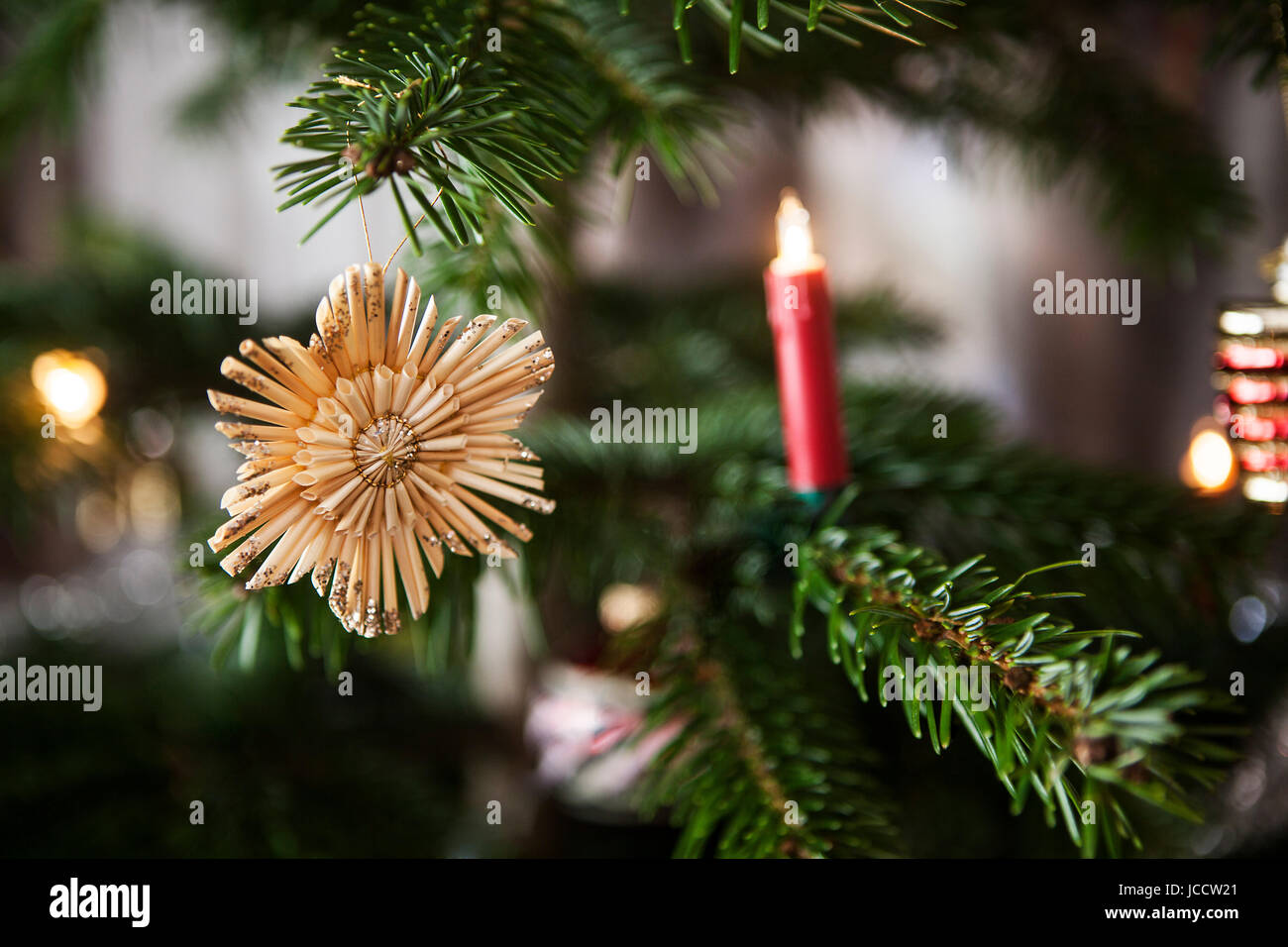 Stelle di paglia e luci appeso a un albero di natale Foto Stock