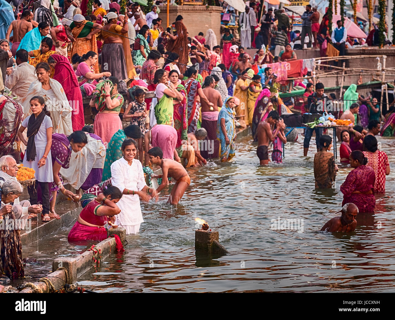 Varanasi, India - 15 novembre 2016: la mattina dopo il dev Diwali Festival, un anonimo giovane donna in bianco le balneazioni in acque sante del Foto Stock