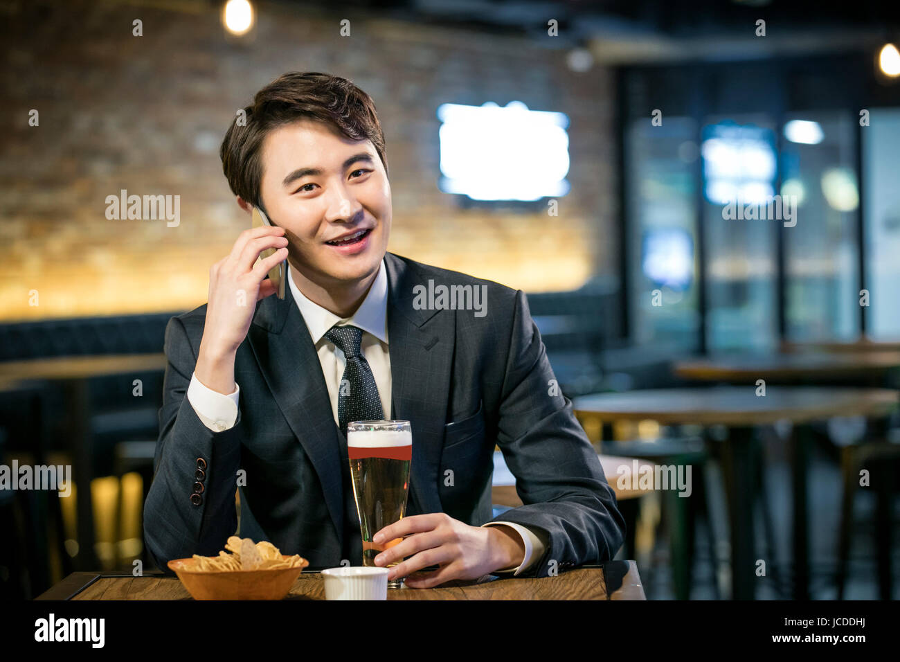 Ritratto di sorridere solo uomo solo da bere al bar Foto Stock