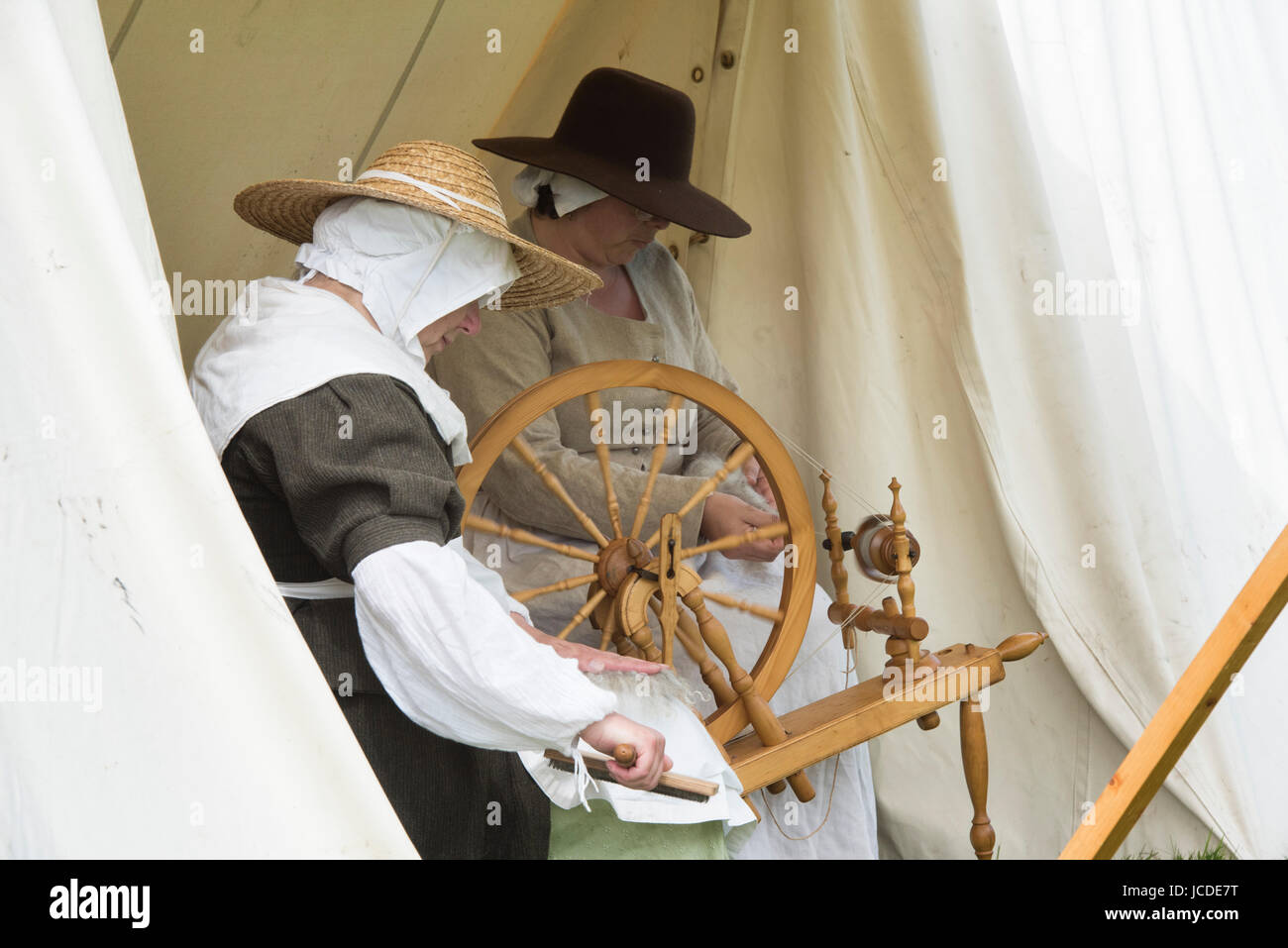 Le donne la filatura in un accampamento presso un Nodo sigillato guerra civile inglese rievocazione storica evento. Charlton park di Malmesbury, Wiltshire, Regno Unito Foto Stock