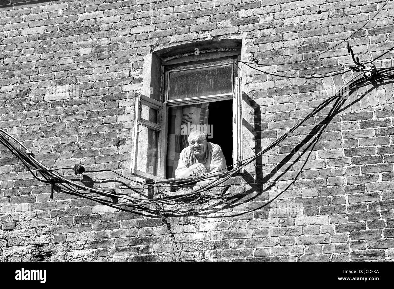 VALAAM, Russia - 15 Ago 2015, la vista di un uomo vecchio che guarda fuori da una finestra di un edificio di mattoni, su 15 Ago 2015 in VALAAM, RUSSIA Foto Stock