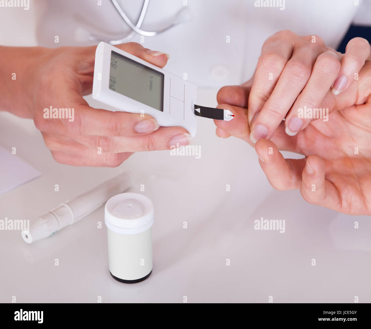 Test medico pazienti un livello di glucosio dopo la puntura il suo dito per  disegnare una goccia di sangue e quindi usando un glycometer digitale Foto  stock - Alamy