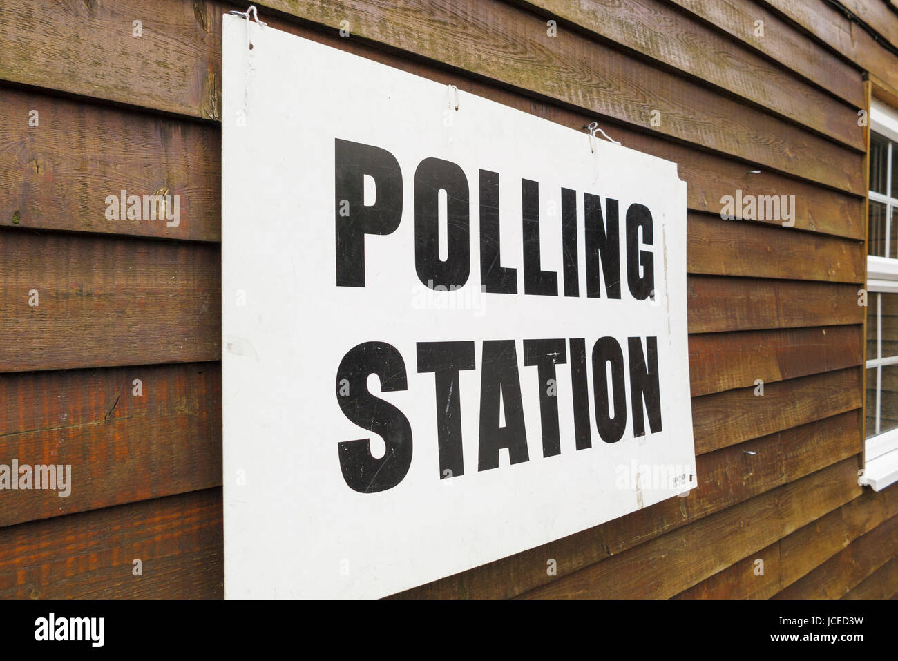 Le elezioni e la democrazia: stazione di polling segno su una parete in legno, Woking, Surrey, Regno Unito Foto Stock