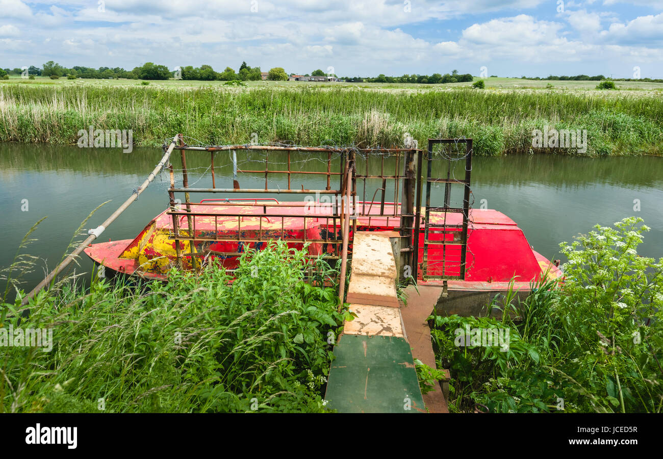Abbandonato il fiume ironclad barca lungo il fiume Hull affiancato da terreni agricoli e ricoperta di vegetazione su una tranquilla mattinata estiva vicino a Beverley, Yorkshire, Regno Unito. Foto Stock