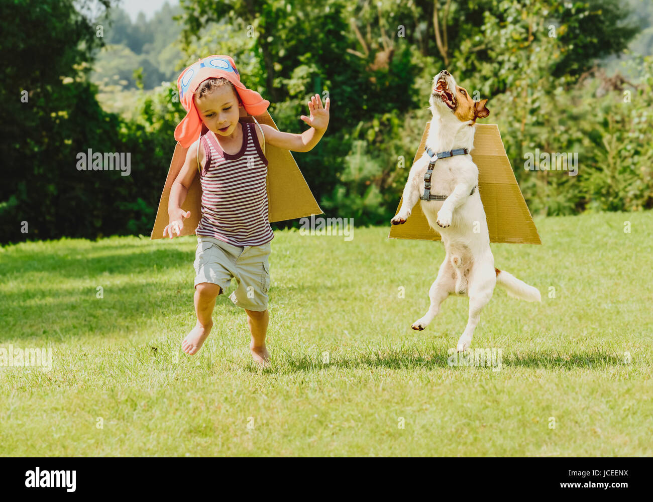 Due amici a giocare ad alta volantini con ali di cartone Foto Stock