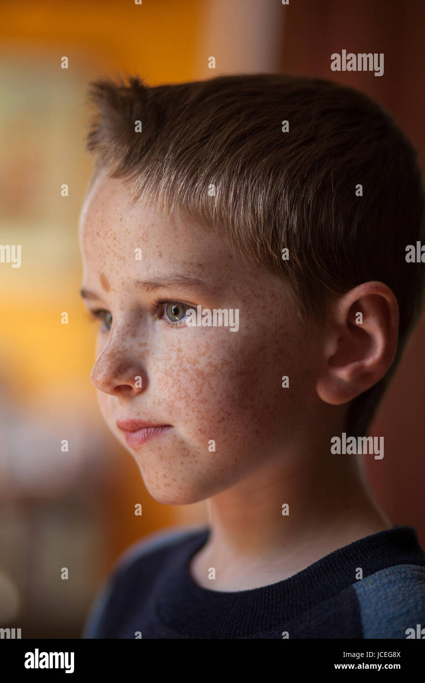 Un determinato e riflessivo ragazzo di 7 anni. Foto Stock