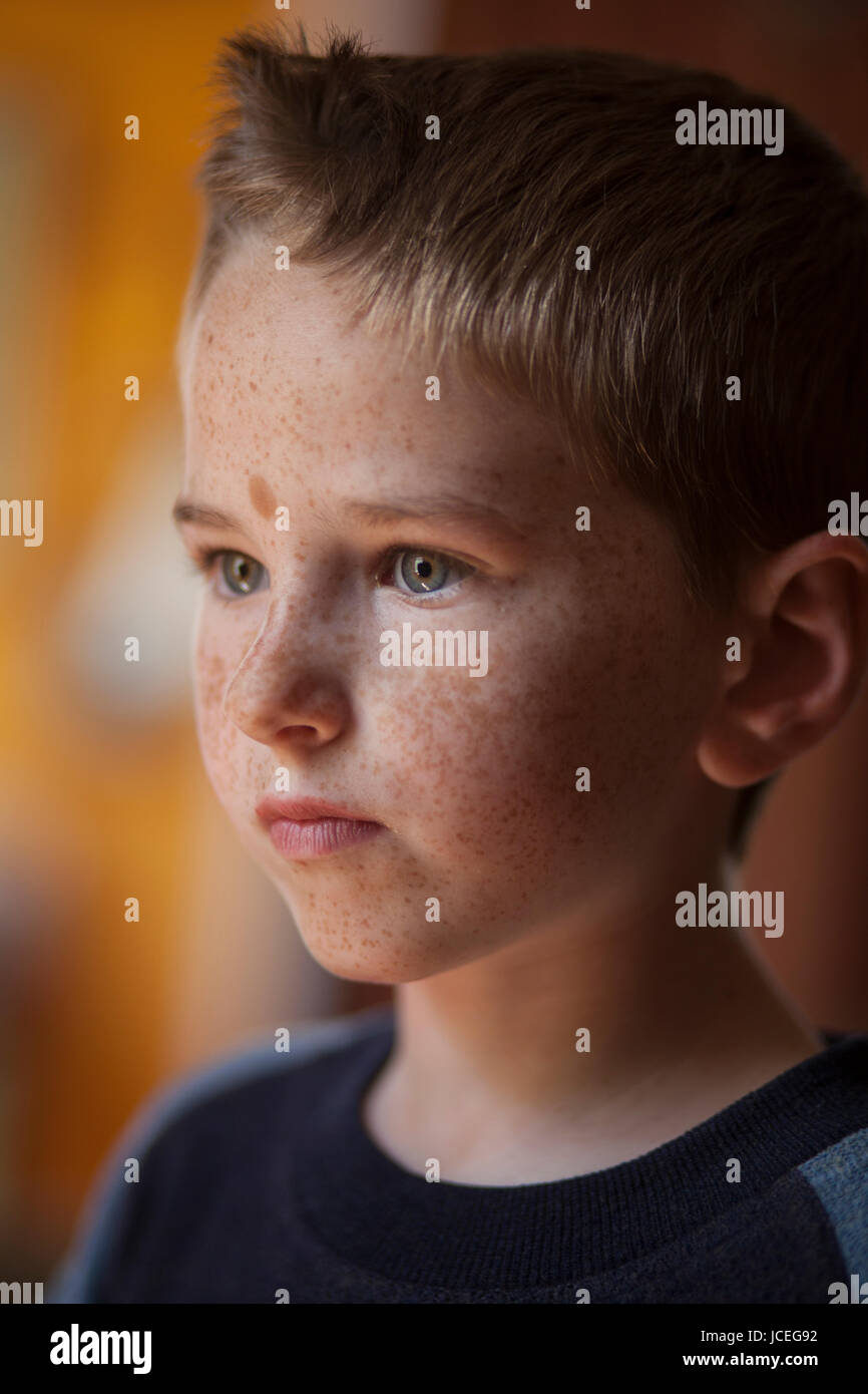 Un determinato e riflessivo ragazzo di 7 anni. Foto Stock