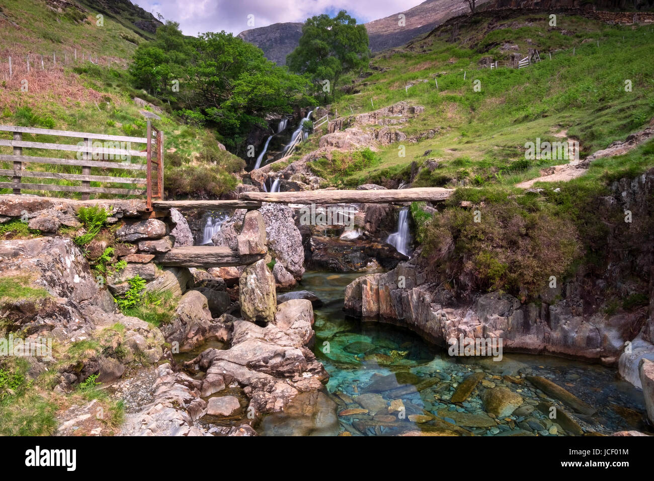 Lastra di pietra passerella e cascate, Cwm Llan, il percorso Watkin, Snowdonia National Park, North Wales, Regno Unito Foto Stock