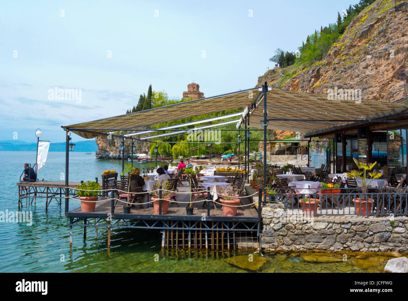 Ristorante terrazza in riva al lago, a Kaneo beach, con San Giovanni a Kaneo chiesa in background, Ohrid Macedonia Foto Stock