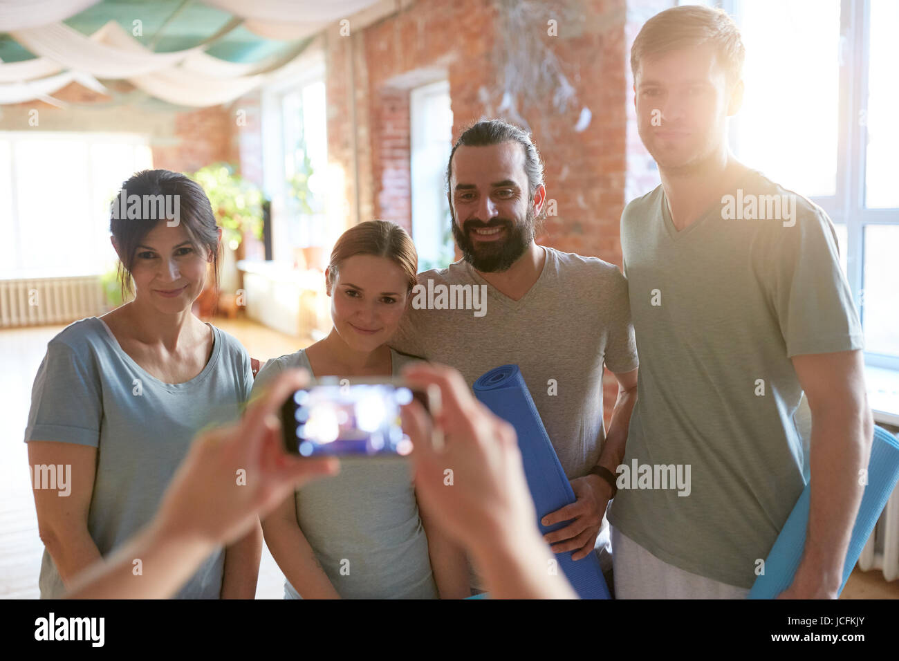 Le persone felici in studio di yoga o palestra a fotografare Foto Stock