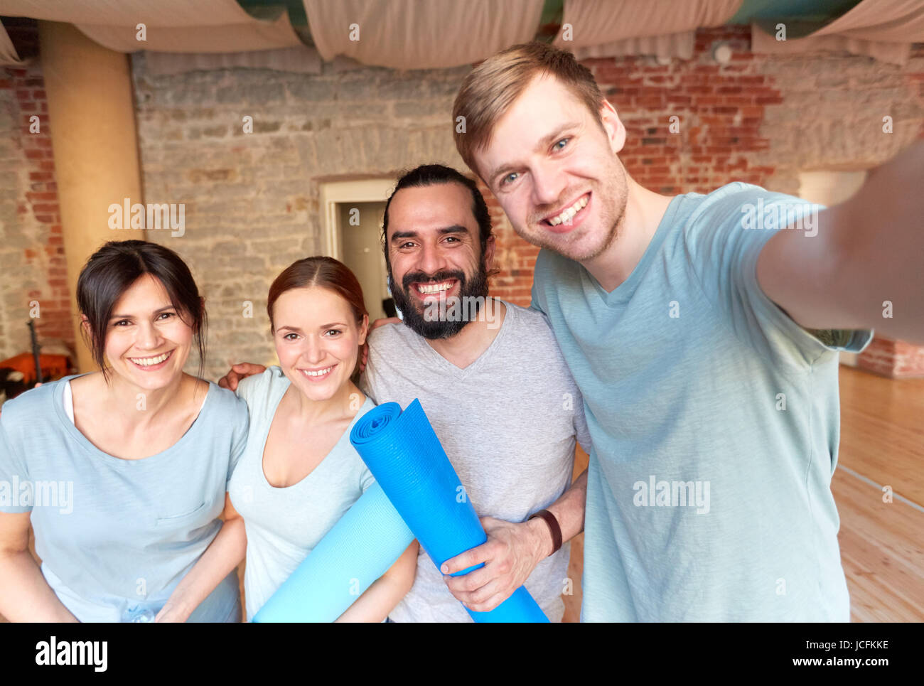 Happy amici a studio di yoga o palestra tenendo selfie Foto Stock