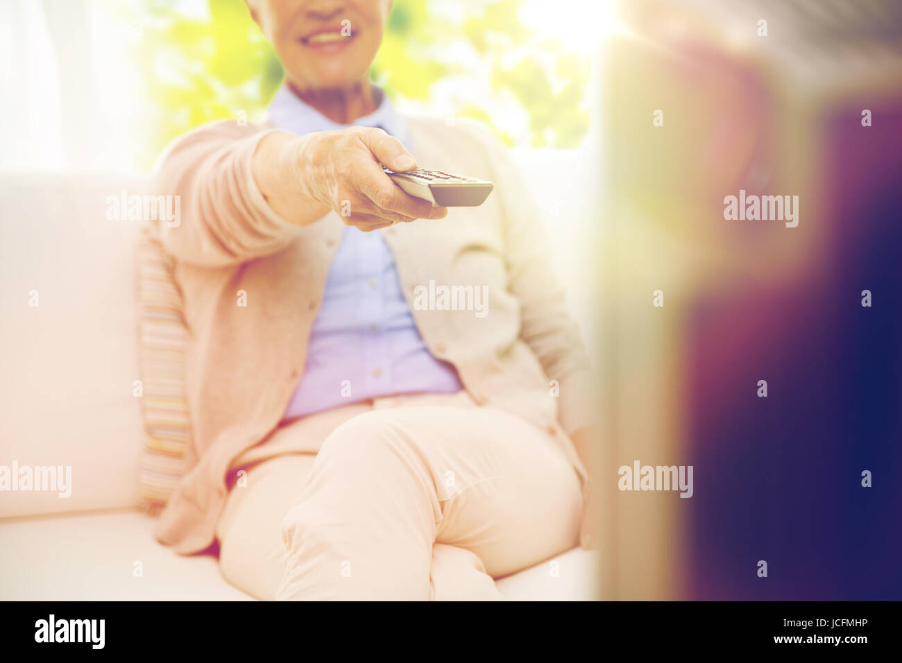 Close up di felice senior donna guardando la tv a casa Foto Stock