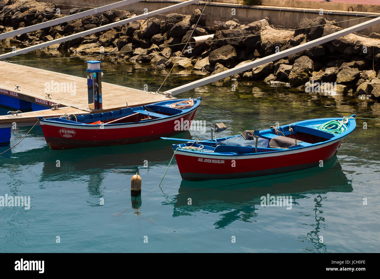 Una coppia di piccoli open lobster barche ormeggiate nel porto dell'isola spagnola di Teneriffe Foto Stock