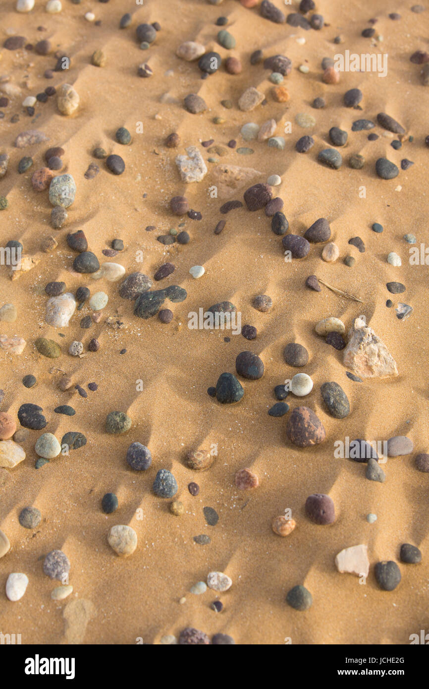 Primo piano di pietre e sabbia sulla spiaggia di Sidi Kaouki, Marocco Foto Stock