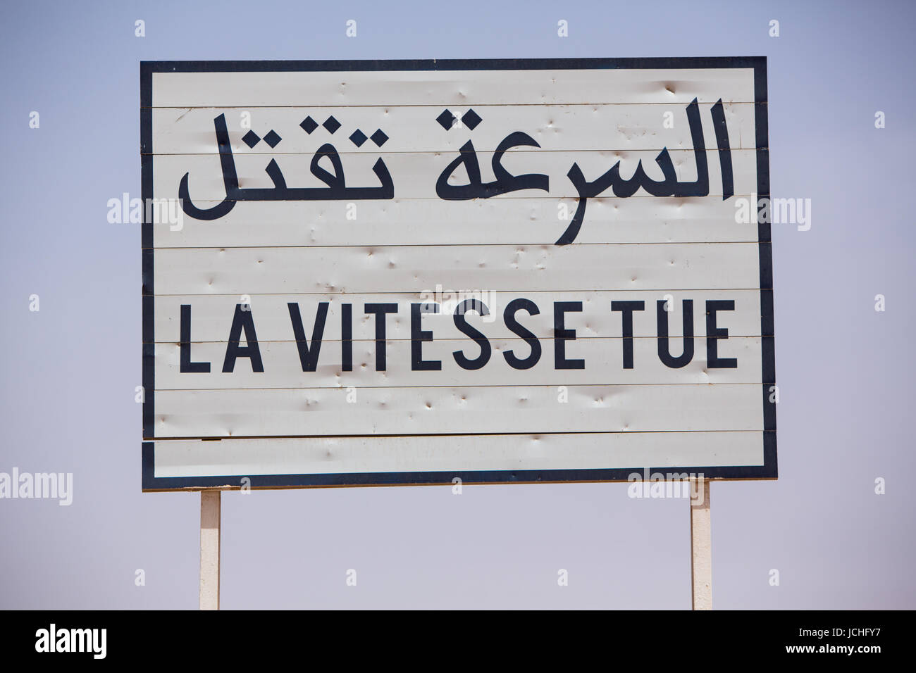 Velocità del traffico uccide cartello stradale scritto in francese e arabo su sfondo blu Foto Stock