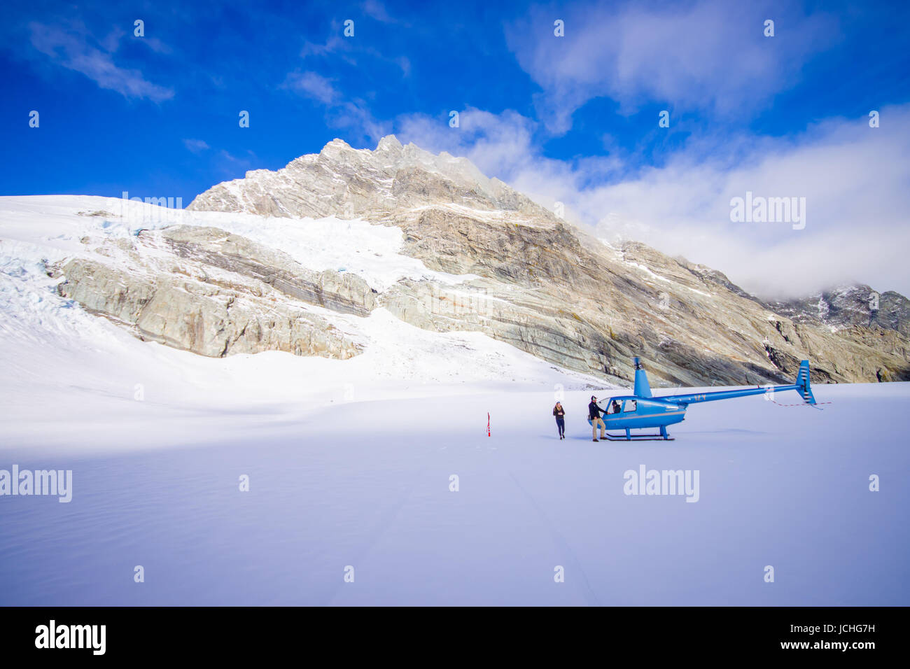 Isola del Sud, Nuova Zelanda - 24 Maggio 2017: elicottero e pilota in attesa sulla neve per i cacciatori nel sud del Westland Alpi del Sud, Nuova Zelanda. Foto Stock