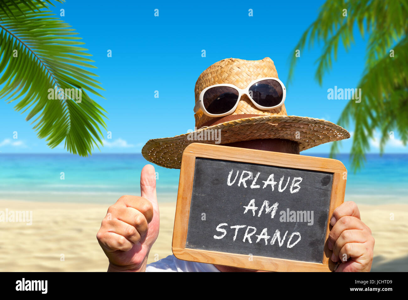 Mann hält Tafel mit Testo: Urlaub am Strand Foto Stock