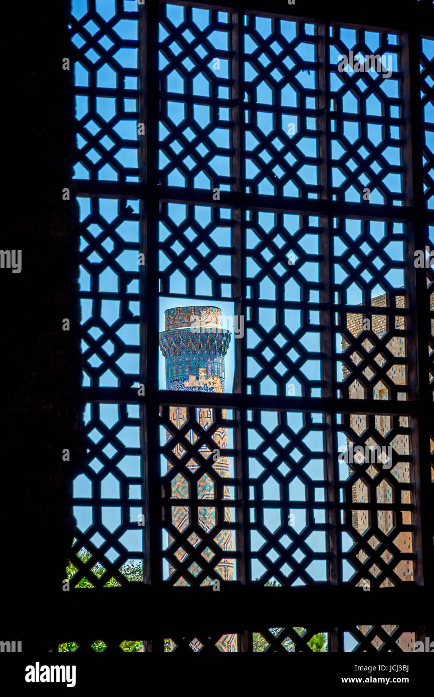 Visualizzare al minareto attraverso la finestra a traliccio, Samarcanda, Uzbekistan Foto Stock