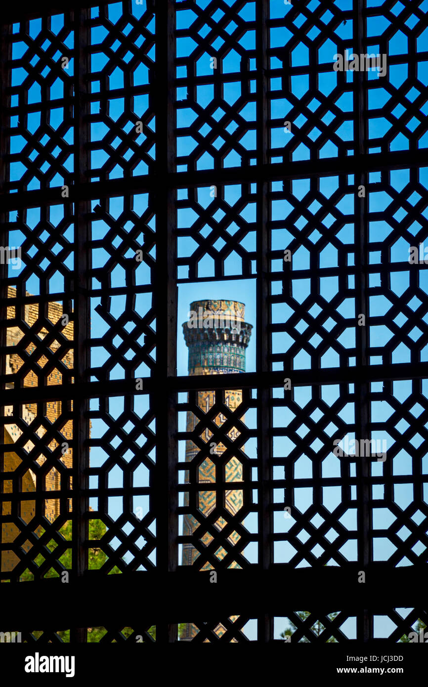 Visualizzare al minareto attraverso la finestra a traliccio, Samarcanda, Uzbekistan Foto Stock