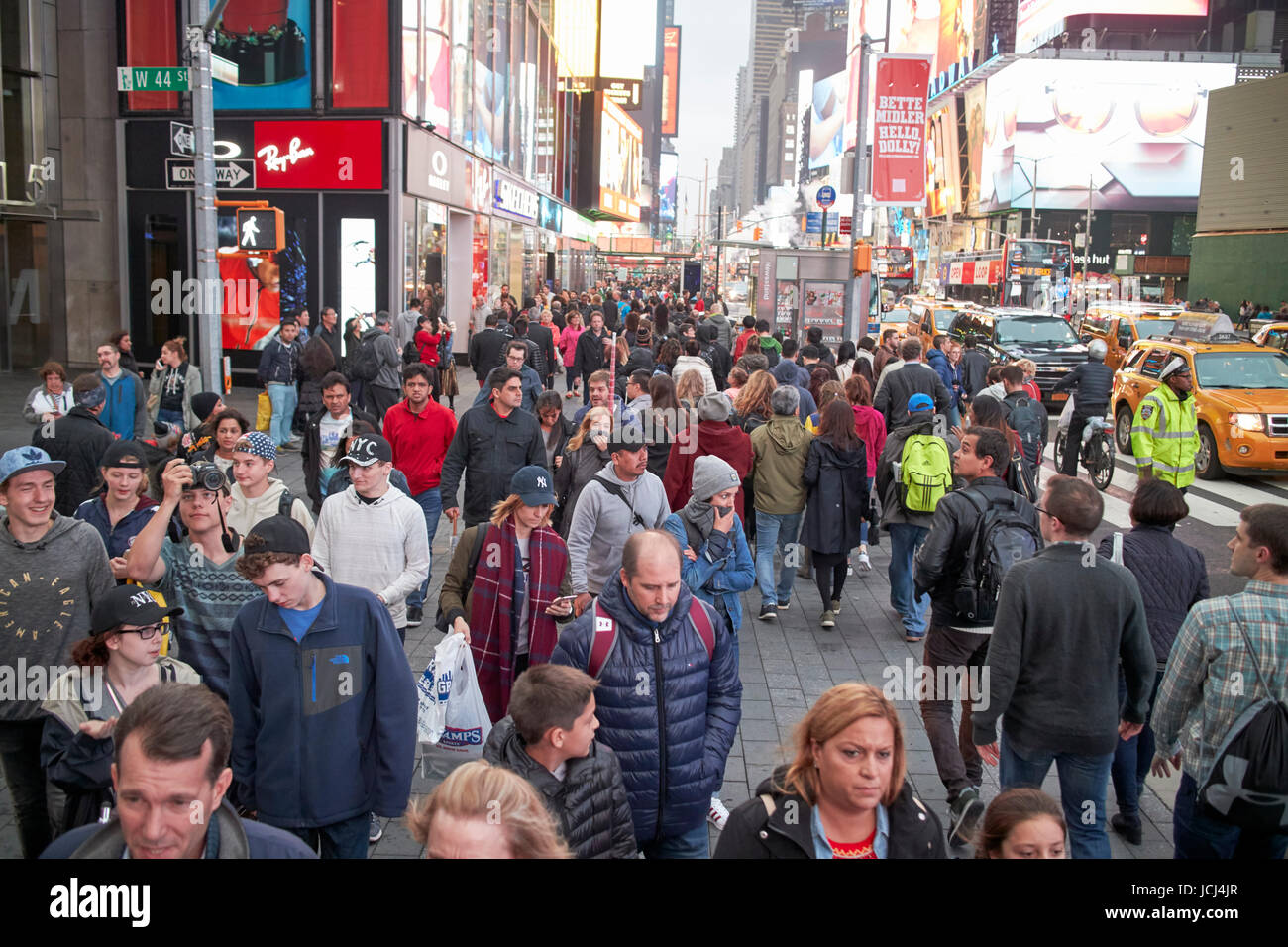 Le persone che attraversano le crosswalk pieno occupato il marciapiede di sera serata a Times Square a New York City USA Foto Stock