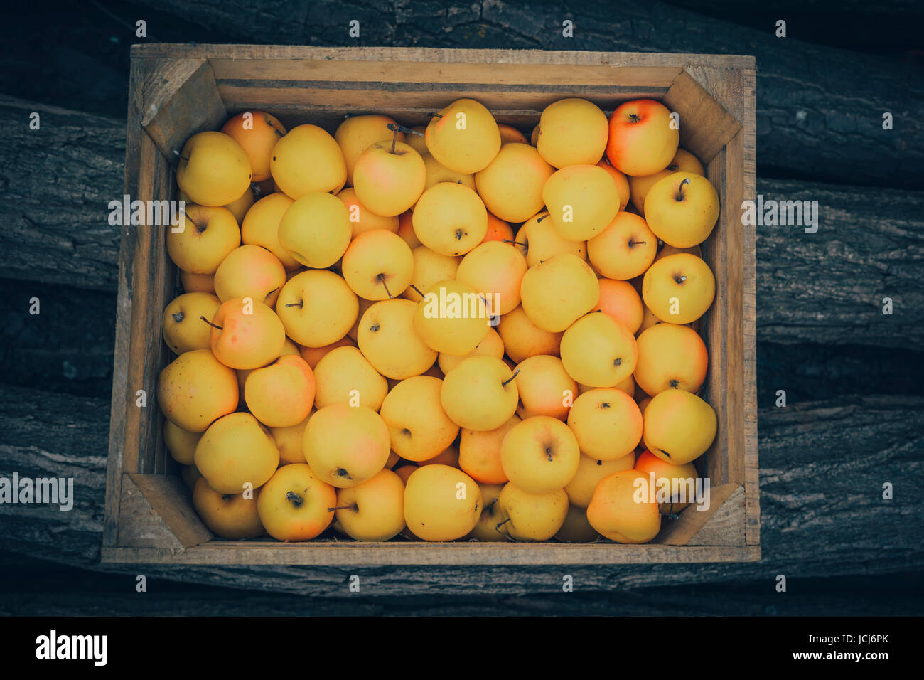 Un gruppo di colore giallo-rosso e fresh apple nella casella su uno sfondo di legno. Foto Stock